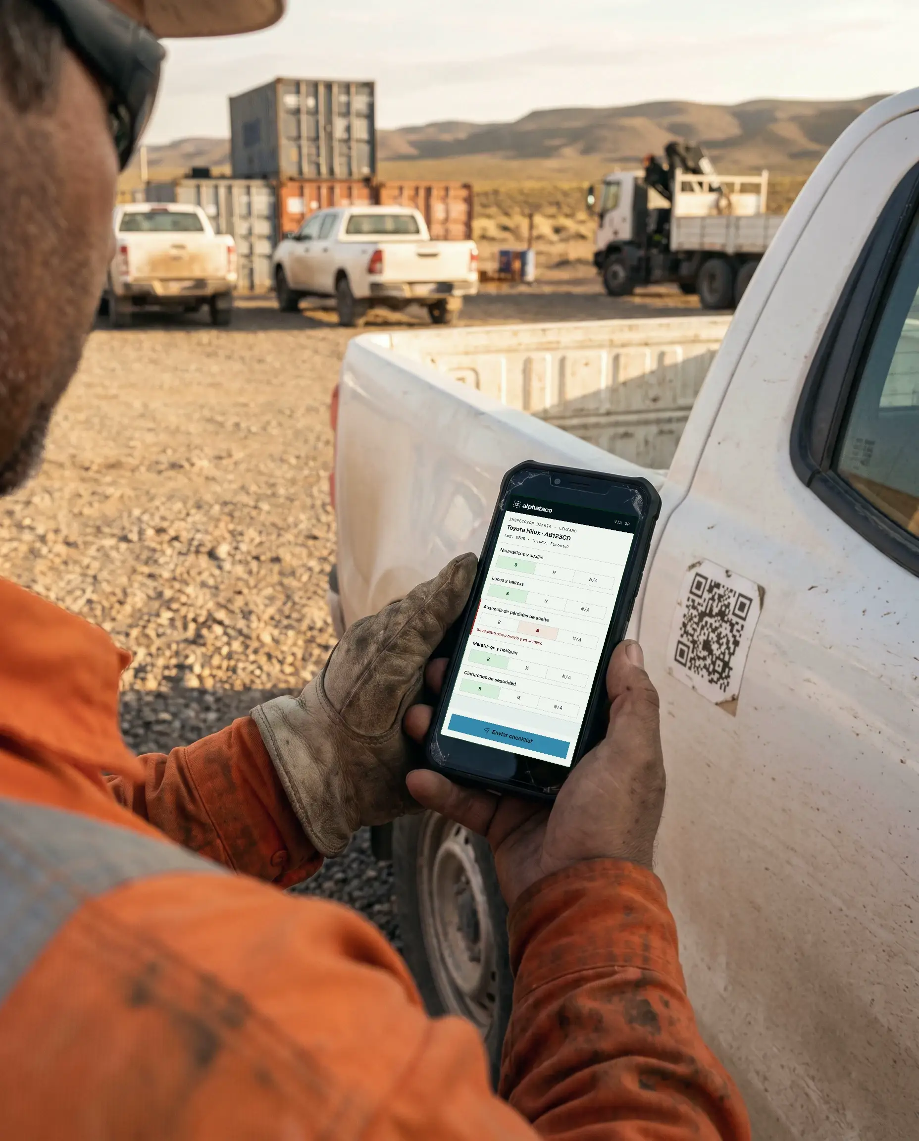 Un chofer con guantes escanea el QR pegado en la puerta de su camioneta y completa el checklist en el celular.