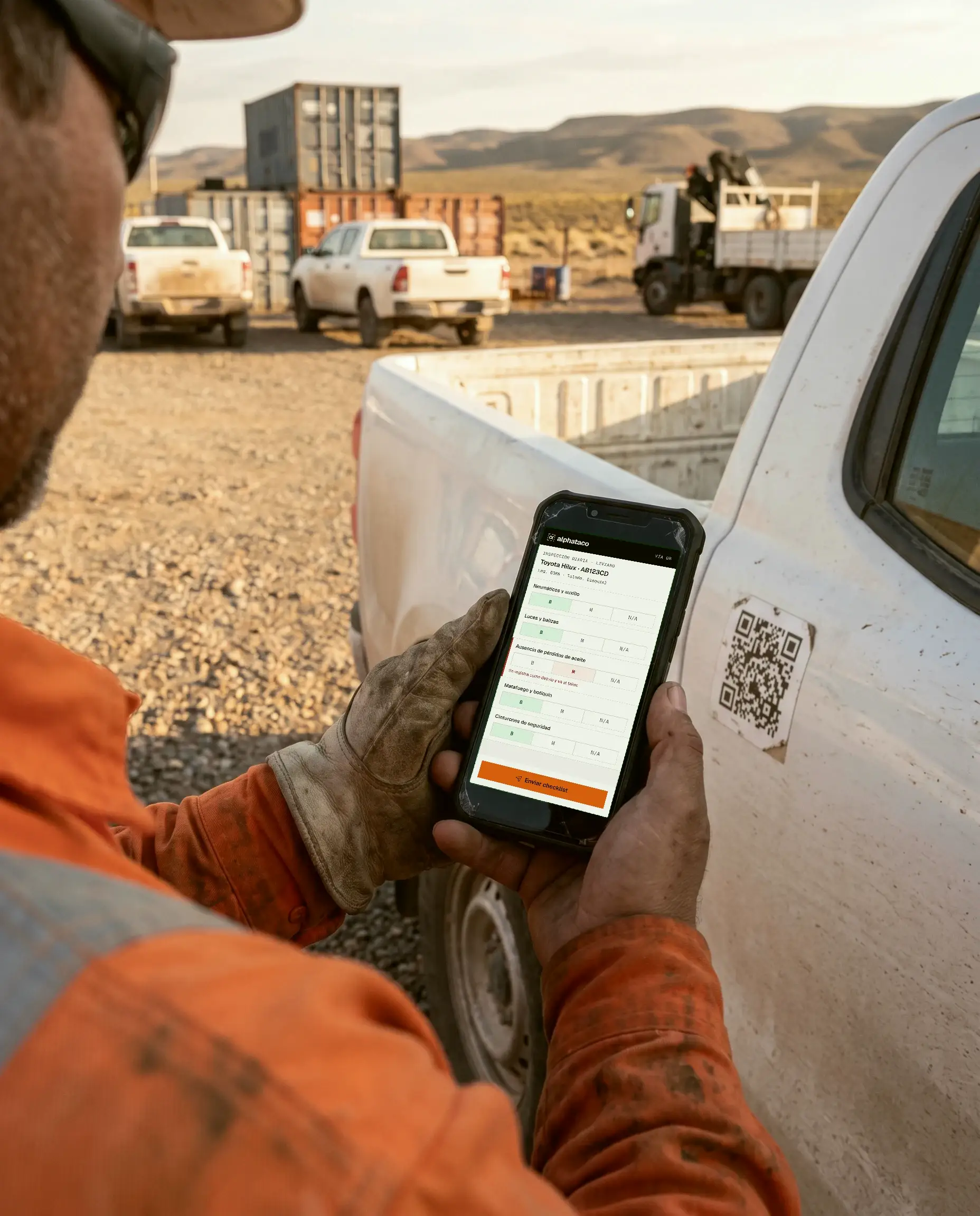 Un chofer con guantes escanea el QR pegado en la puerta de su camioneta y completa el checklist en el celular.